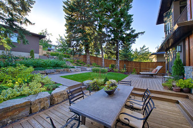 This is an example of a mid-sized traditional backyard deck in Calgary with no cover.