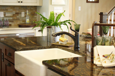 Example of a transitional u-shaped medium tone wood floor open concept kitchen design in Richmond with a farmhouse sink, recessed-panel cabinets, beige cabinets, granite countertops, multicolored backsplash, stone tile backsplash, stainless steel appliances and an island