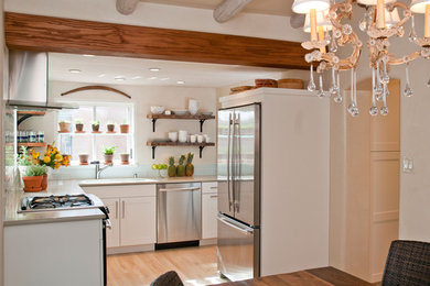 Mid-sized southwest l-shaped light wood floor and beige floor eat-in kitchen photo in Albuquerque with an undermount sink, shaker cabinets, white cabinets, blue backsplash, glass tile backsplash, stainless steel appliances and no island