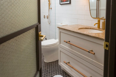 Inspiration for a mid-sized transitional white tile and ceramic tile ceramic tile, brown floor and single-sink bathroom remodel in Cincinnati with shaker cabinets, white cabinets, a two-piece toilet, an undermount sink, marble countertops, a hinged shower door, brown countertops and a built-in vanity