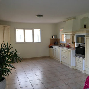 Design ideas for a large beach style galley open plan kitchen in Nantes with beaded inset cabinets, beige cabinets, wood benchtops, grey splashback, cement tile splashback, stainless steel appliances, ceramic floors, with island, pink floor and brown benchtop.