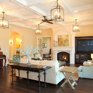 Diseño de salón mediterráneo con paredes beige, chimenea tradicional y pared multimedia