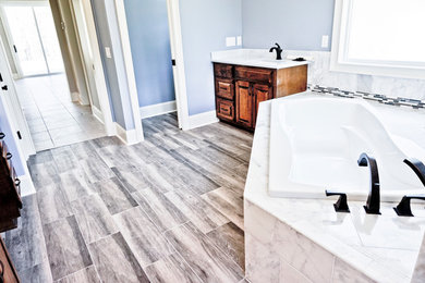 Bathroom - large contemporary master gray tile and marble tile porcelain tile bathroom idea in Other with raised-panel cabinets, brown cabinets, blue walls, a drop-in sink and marble countertops