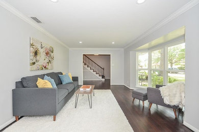 Mid-sized transitional enclosed medium tone wood floor and brown floor living room photo in Houston with gray walls and no tv