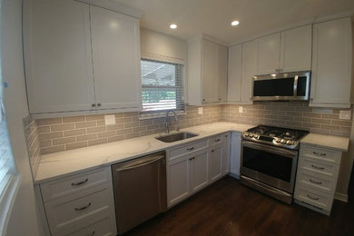 Inspiration for a small transitional l-shaped dark wood floor and brown floor enclosed kitchen remodel in Other with an undermount sink, shaker cabinets, white cabinets, quartz countertops, gray backsplash, subway tile backsplash, stainless steel appliances and white countertops