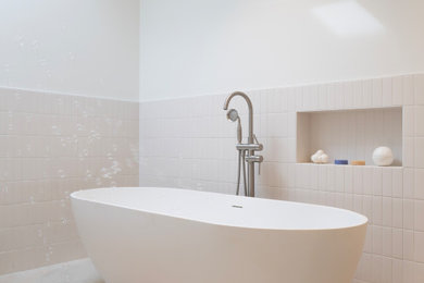 Freestanding bathtub - mid-sized contemporary master white tile and ceramic tile ceramic tile, beige floor and single-sink freestanding bathtub idea in San Francisco with flat-panel cabinets, medium tone wood cabinets, a wall-mount toilet, white walls, a drop-in sink, quartz countertops, white countertops, a niche and a floating vanity