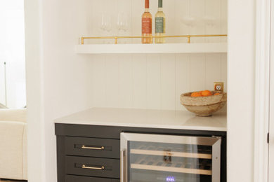Dry bar - small transitional single-wall light wood floor and brown floor dry bar idea in Houston with no sink, shaker cabinets, black cabinets, quartz countertops, white backsplash, shiplap backsplash and white countertops