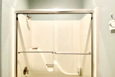 他の地域にあるトランジショナルスタイルのおしゃれな浴室 (アルコーブ型浴槽、シャワー付き浴槽	、引戸のシャワー) の写真