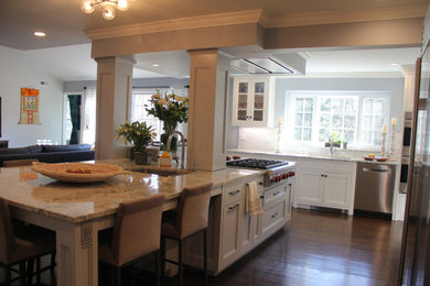 Inspiration for a large transitional l-shaped dark wood floor and brown floor eat-in kitchen remodel in New York with an undermount sink, recessed-panel cabinets, gray cabinets, granite countertops, white backsplash, ceramic backsplash, stainless steel appliances, an island and gray countertops