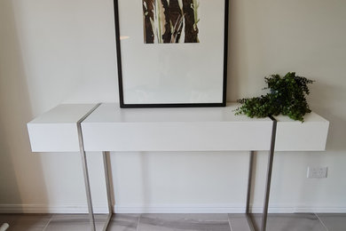 Small contemporary entry hall in Brisbane with white walls, ceramic floors and grey floor.