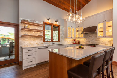 This is an example of a mid-sized transitional u-shaped eat-in kitchen in Denver with a single-bowl sink, shaker cabinets, white cabinets, quartz benchtops, multi-coloured splashback, subway tile splashback, panelled appliances, light hardwood floors, with island, brown floor and white benchtop.