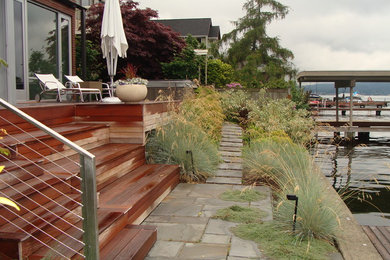 This is an example of a large modern backyard full sun garden in Seattle with a water feature and decking.