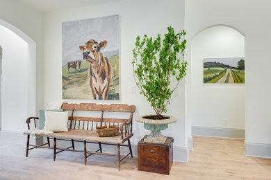 Inspiration for a country entryway in Orange County with white walls, light hardwood floors and beige floor.