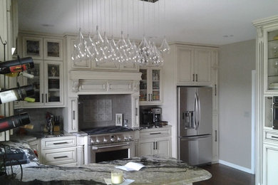 Enclosed kitchen - mid-sized transitional l-shaped dark wood floor and brown floor enclosed kitchen idea in Other with an undermount sink, raised-panel cabinets, distressed cabinets, granite countertops, gray backsplash, subway tile backsplash, stainless steel appliances and a peninsula