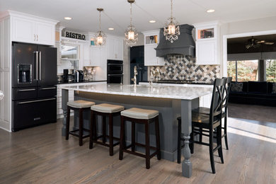 Inspiration for a large timeless l-shaped medium tone wood floor and gray floor open concept kitchen remodel in Minneapolis with a double-bowl sink, raised-panel cabinets, white cabinets, gray backsplash, ceramic backsplash, stainless steel appliances, an island, white countertops and quartz countertops