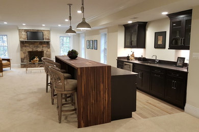 Design ideas for a mid-sized transitional single-wall seated home bar in DC Metro with an undermount sink, recessed-panel cabinets, black cabinets, quartz benchtops, carpet and beige floor.