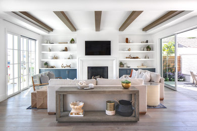 This is an example of a large modern open concept living room in Orange County with white walls, medium hardwood floors, a standard fireplace, a tile fireplace surround, a wall-mounted tv and brown floor.