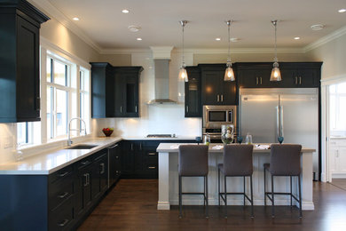 Kitchen - transitional l-shaped dark wood floor kitchen idea in Vancouver with an undermount sink, shaker cabinets, dark wood cabinets, quartz countertops, white backsplash, ceramic backsplash, stainless steel appliances and an island