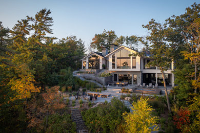 Inspiration for a huge country two-story mixed siding house exterior remodel in Toronto with a metal roof and a black roof