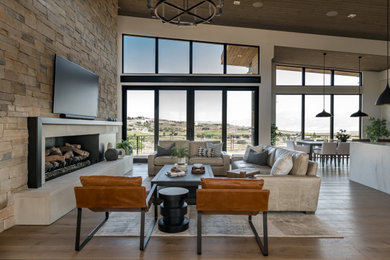 Inspiration for a mid-sized contemporary open concept brown floor, wood ceiling, vaulted ceiling and medium tone wood floor living room remodel in Salt Lake City with beige walls, a standard fireplace, a stone fireplace and a wall-mounted tv