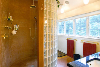 Example of a mid-sized trendy master glass tile concrete floor doorless shower design in Philadelphia with an undermount sink, medium tone wood cabinets, granite countertops, white walls and raised-panel cabinets