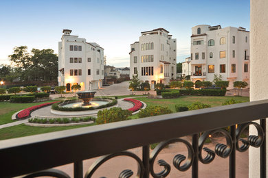 Large transitional white three-story stucco townhouse exterior idea in Houston with a tile roof