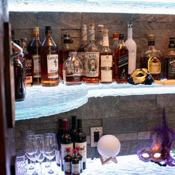 Glass private bar and glass stair treads inside a man cave in Michigan