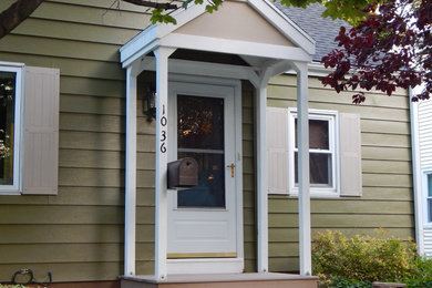 Example of a mid-sized classic green two-story wood house exterior design in Other