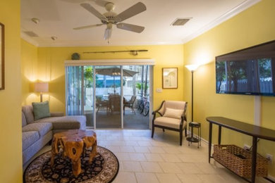 Large elegant enclosed ceramic tile and beige floor living room photo in Miami with yellow walls, no fireplace and a wall-mounted tv