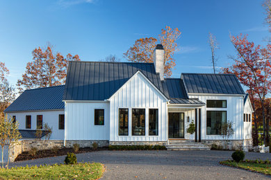 Inspiration for a large farmhouse white two-story concrete and board and batten exterior home remodel in Richmond with a metal roof and a black roof