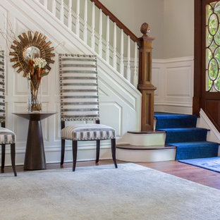 Inspiration för mellanstora eklektiska ingångspartier, med heltäckningsmatta, en enkeldörr, mellanmörk trädörr, beige väggar och brunt golv