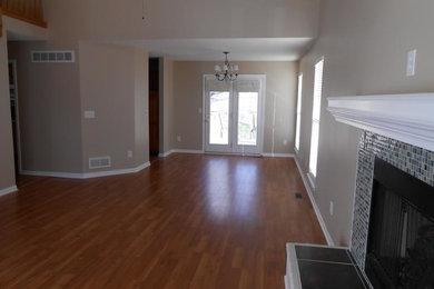 Example of a mid-sized classic medium tone wood floor and brown floor living room design in Toronto with beige walls, a standard fireplace and a tile fireplace
