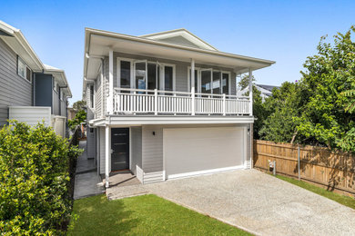 This is an example of a mid-sized two-storey grey house exterior in Brisbane with concrete fiberboard siding, a metal roof, a grey roof and clapboard siding.