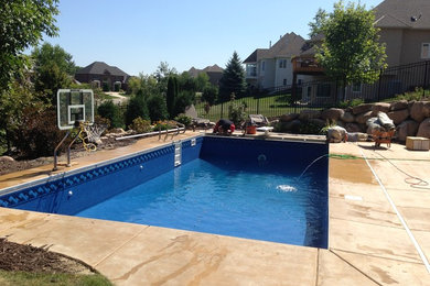 Medium sized traditional back rectangular lengths swimming pool in Minneapolis with concrete paving.