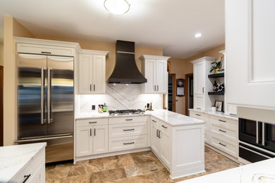 Inspiration for a transitional u-shaped porcelain tile and brown floor eat-in kitchen remodel in Minneapolis with an undermount sink, flat-panel cabinets, yellow cabinets, quartz countertops, white backsplash, quartz backsplash, stainless steel appliances and white countertops