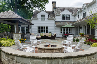 Patio kitchen - mid-sized traditional backyard stone patio kitchen idea with a gazebo