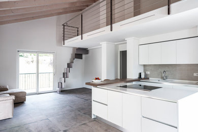 Photo of a large contemporary u-shaped open plan kitchen in Other with white cabinets, grey splashback, with island, grey floor, white benchtop, a drop-in sink, flat-panel cabinets, quartzite benchtops, porcelain splashback, stainless steel appliances and porcelain floors.