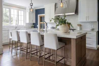 Large transitional u-shaped medium tone wood floor and brown floor open concept kitchen photo in Milwaukee with an undermount sink, shaker cabinets, white cabinets, quartz countertops, gray backsplash, marble backsplash, stainless steel appliances, an island and white countertops