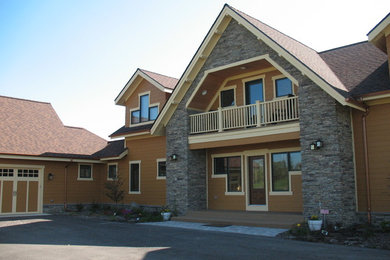 Example of a large classic brown two-story mixed siding house exterior design in Detroit with a hip roof and a shingle roof