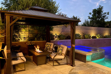 Pool landscaping - large contemporary backyard stone and rectangular infinity pool landscaping idea in San Diego