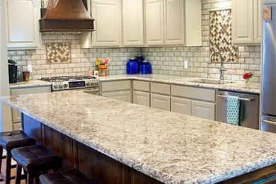 Eat-in kitchen - mid-sized contemporary u-shaped medium tone wood floor and brown floor eat-in kitchen idea in Wichita with a drop-in sink, beaded inset cabinets, white cabinets, granite countertops, beige backsplash, subway tile backsplash, stainless steel appliances and an island