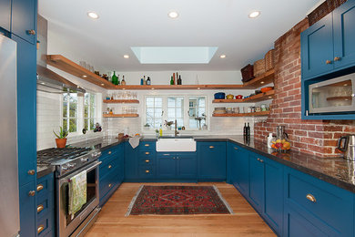Inspiration for a cottage u-shaped light wood floor and beige floor kitchen remodel in Vancouver with a farmhouse sink, shaker cabinets, blue cabinets, white backsplash, subway tile backsplash, stainless steel appliances and no island