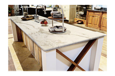 Cottage kitchen photo with a farmhouse sink, marble countertops and an island