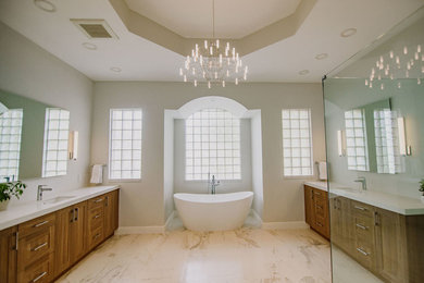 Large transitional master white tile and porcelain tile porcelain tile and white floor bathroom photo in Miami with recessed-panel cabinets, medium tone wood cabinets, a two-piece toilet, white walls, an undermount sink, quartz countertops, a hinged shower door and white countertops