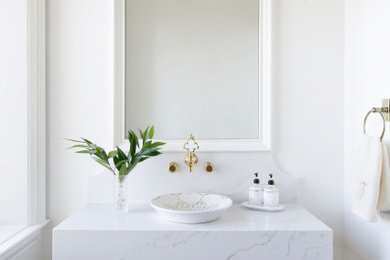 Inspiration for a mid-sized transitional white tile powder room remodel in Nashville with a one-piece toilet, white walls, a vessel sink and white countertops