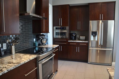 Kitchen - large contemporary kitchen idea in Toronto with an undermount sink, flat-panel cabinets, dark wood cabinets, granite countertops, gray backsplash, glass tile backsplash, stainless steel appliances and a peninsula