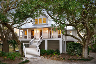 Large beach style white two-story concrete fiberboard house exterior photo in Charleston with a hip roof and a metal roof