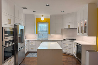 Kitchen pantry - large traditional u-shaped medium tone wood floor and brown floor kitchen pantry idea in Miami with an undermount sink, shaker cabinets, white cabinets, marble countertops, white backsplash, marble backsplash, stainless steel appliances, an island and white countertops