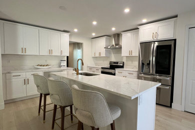 Transitional vinyl floor eat-in kitchen photo in Tampa with an undermount sink, shaker cabinets, white cabinets, quartzite countertops, stainless steel appliances, an island and white countertops