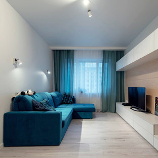 Idee per un piccolo soggiorno minimal chiuso con pareti bianche, pavimento in laminato e TV autoportante